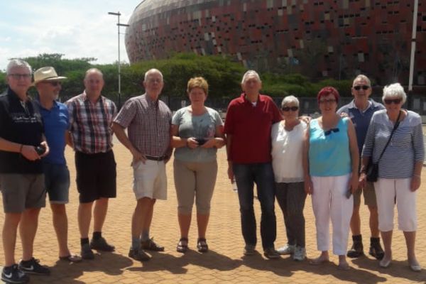 Picture of Soweto tour guests in front of stadium