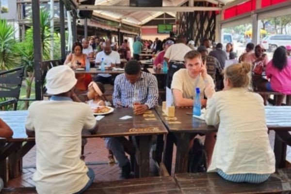 Picture of group of people eating a meal in Soweto